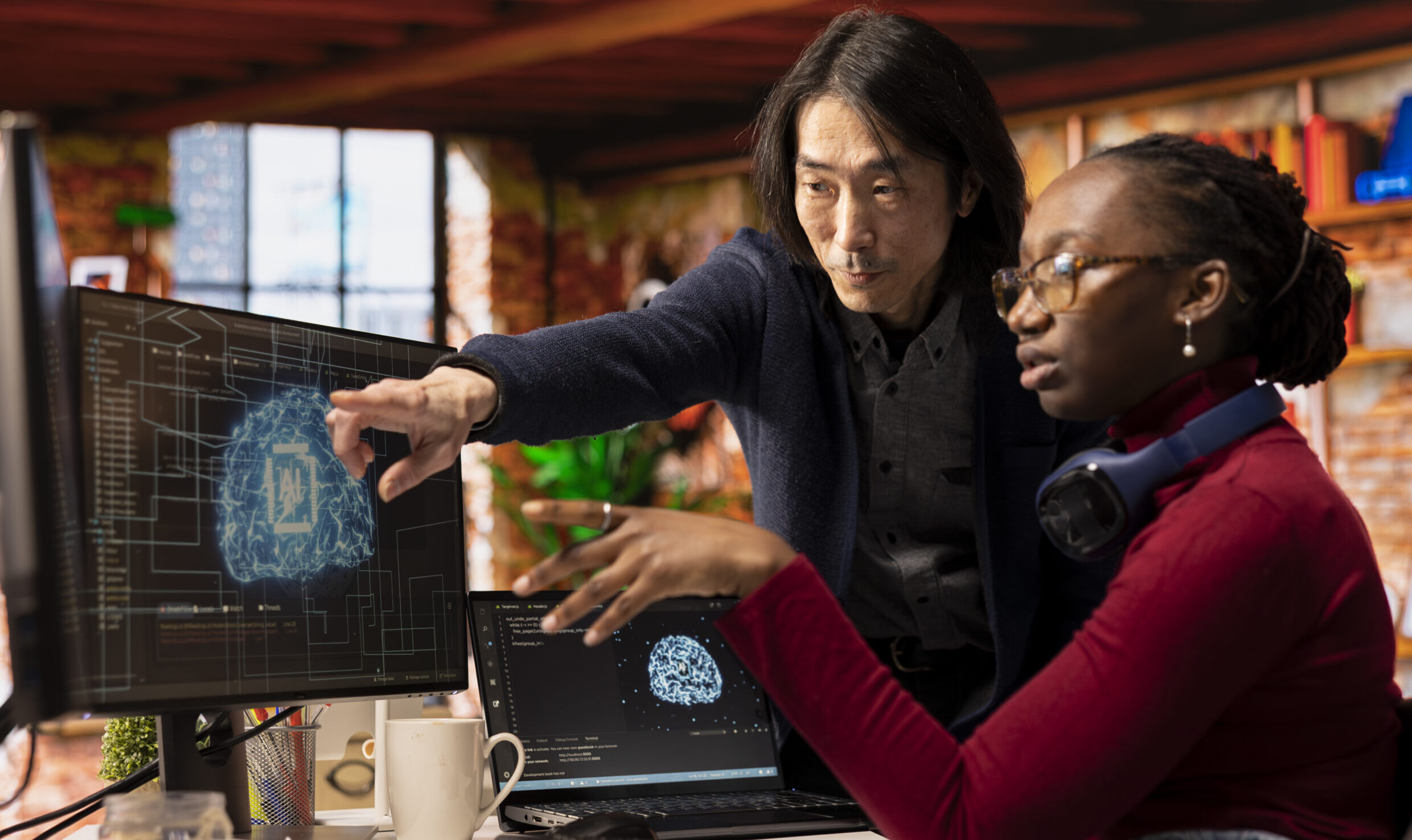 Man in AI startup office CTO position overseeing software technician implementing machine learning. Artificial intelligence tech venture experienced supervisor helps staff member to fix code bugs